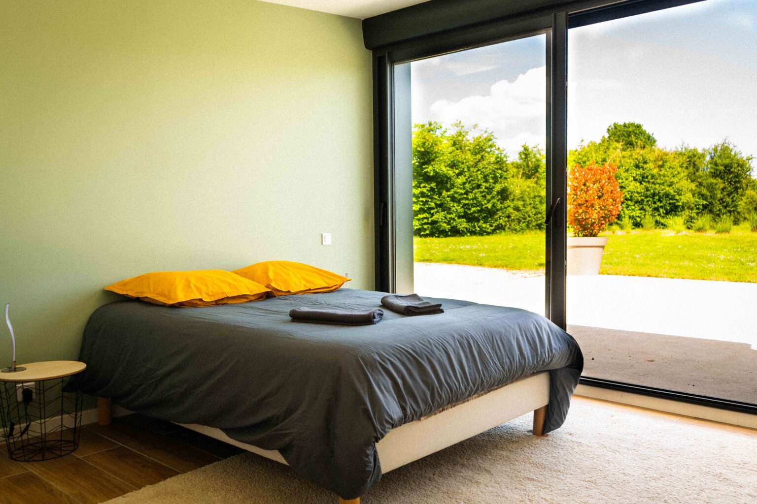 Chambre avec vue sur le jardin depuis une baie vitrée